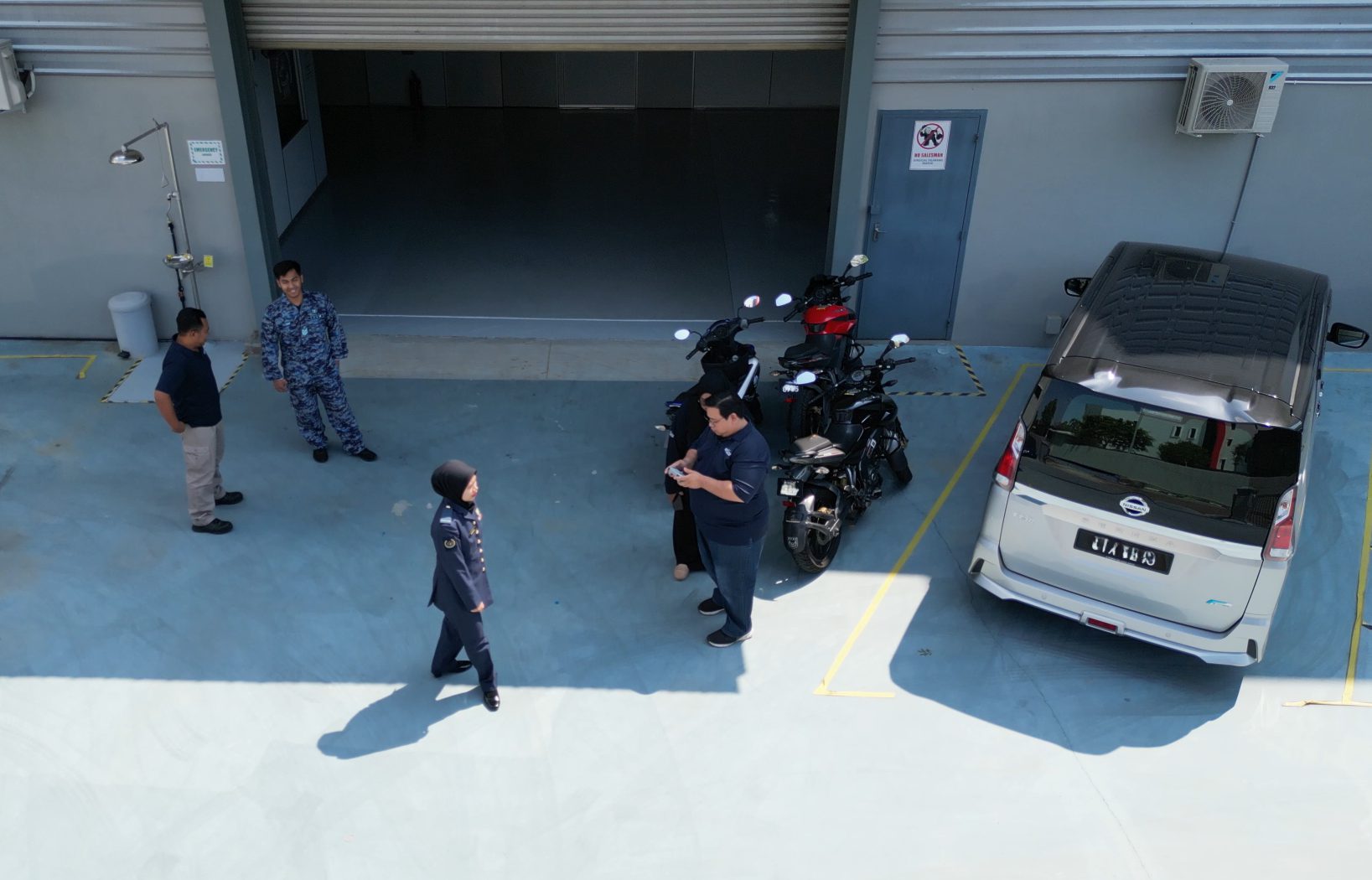 Aerial frame of the G7 Technology apron, with detection boxes drawn around personnel, motorcycles and a vehicle.